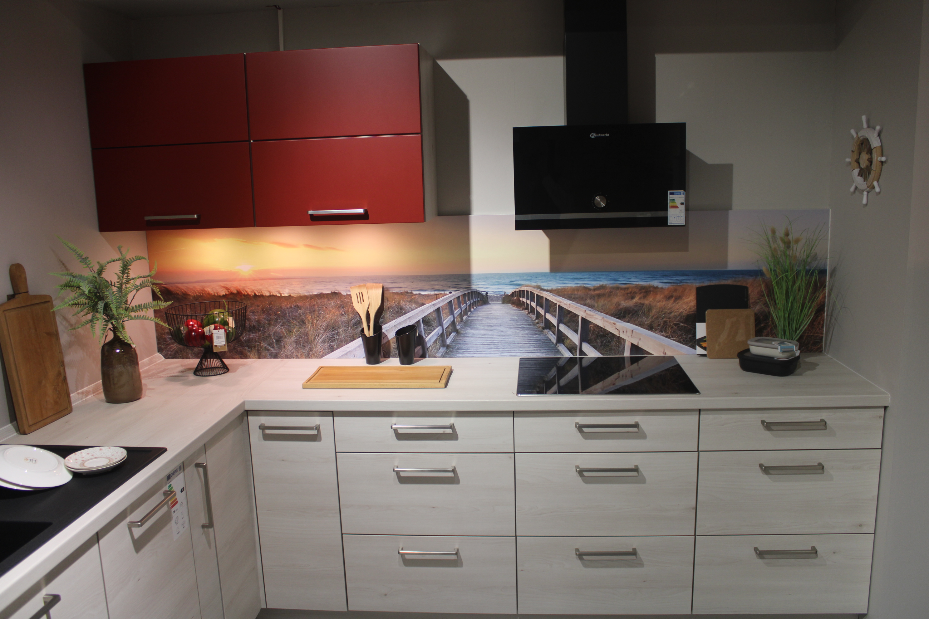 Musterküche, in Kuruna Birke und rot, Griffe Edelstahloptik - Nolte Manhattan